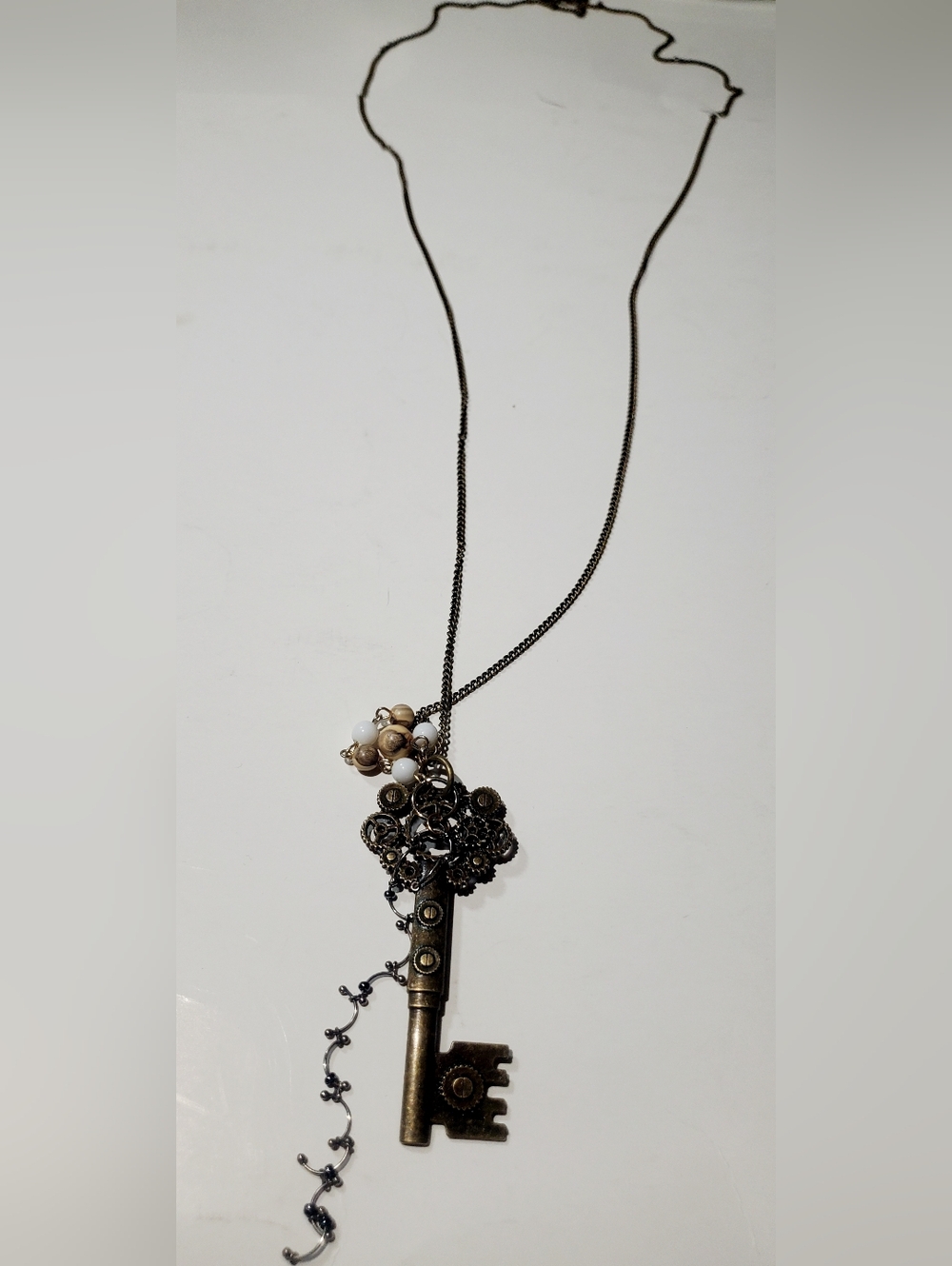 Vintage-Inspired Black and Gold Key Pendant Necklace with White Bead Cluster